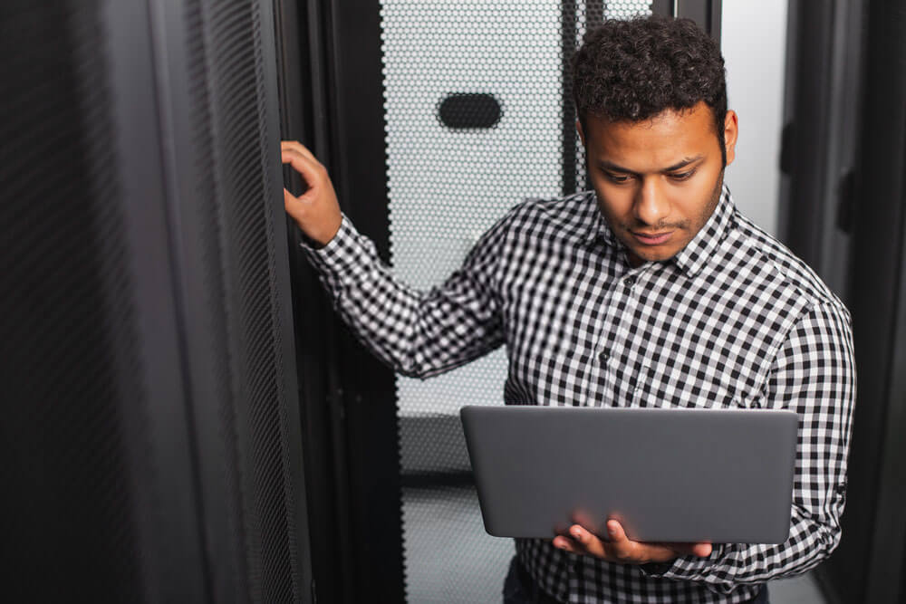 man with his laptop at the server room